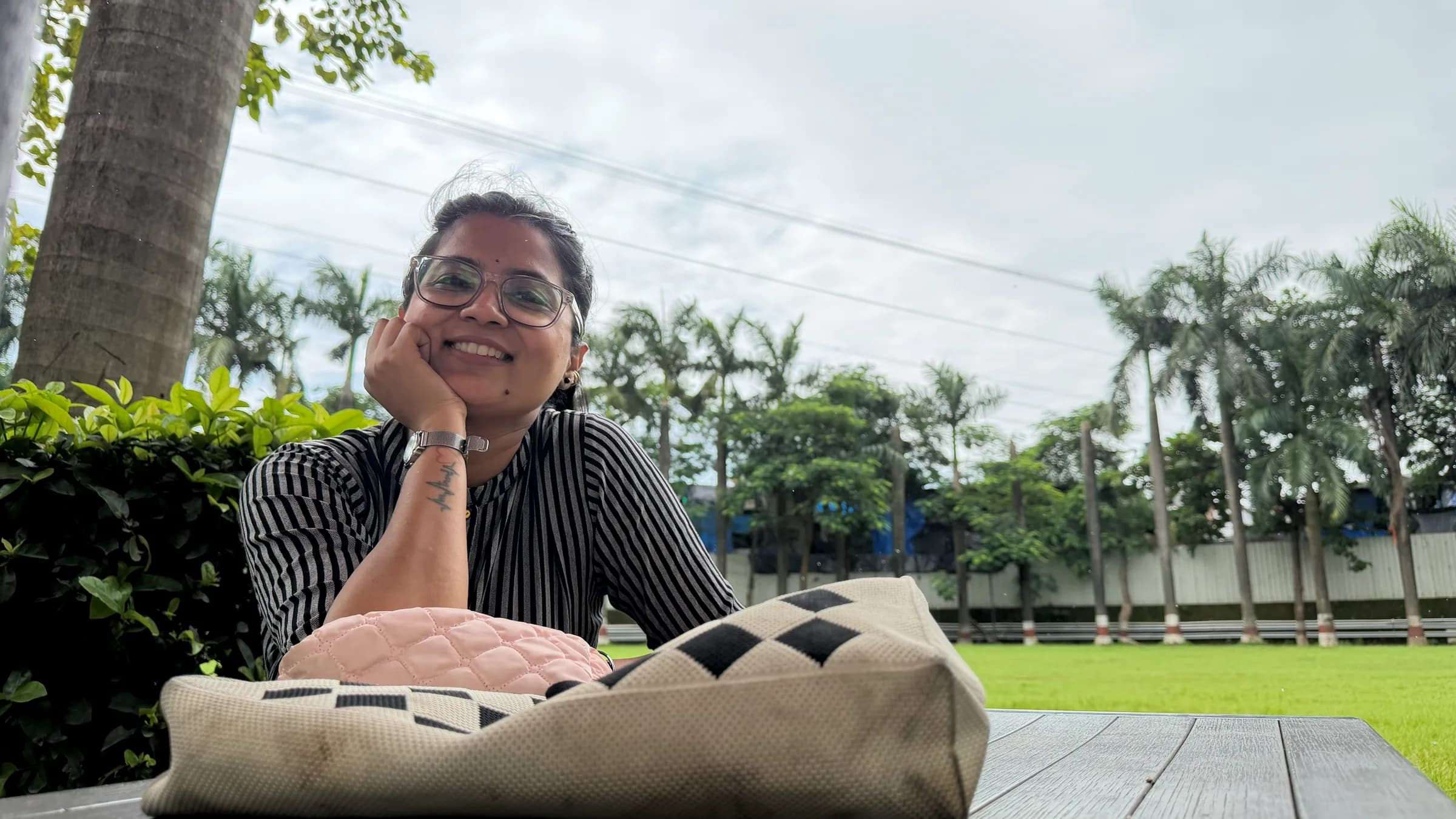 Prof. Sangeeta Wankhade smiling at an outdoor table, chin resting on one hand